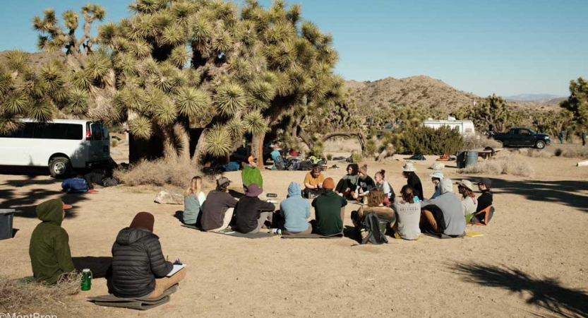 a group of people sit in a circle in Joshua Tree National Park